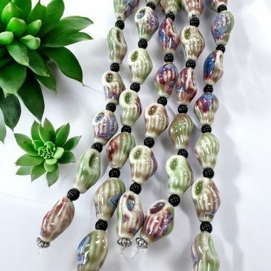 Perle ceramica verde, forma lumaca, smaltatura Flambé, misura 14x21mm, filo 9pz, marchio Gioie d'Oriente